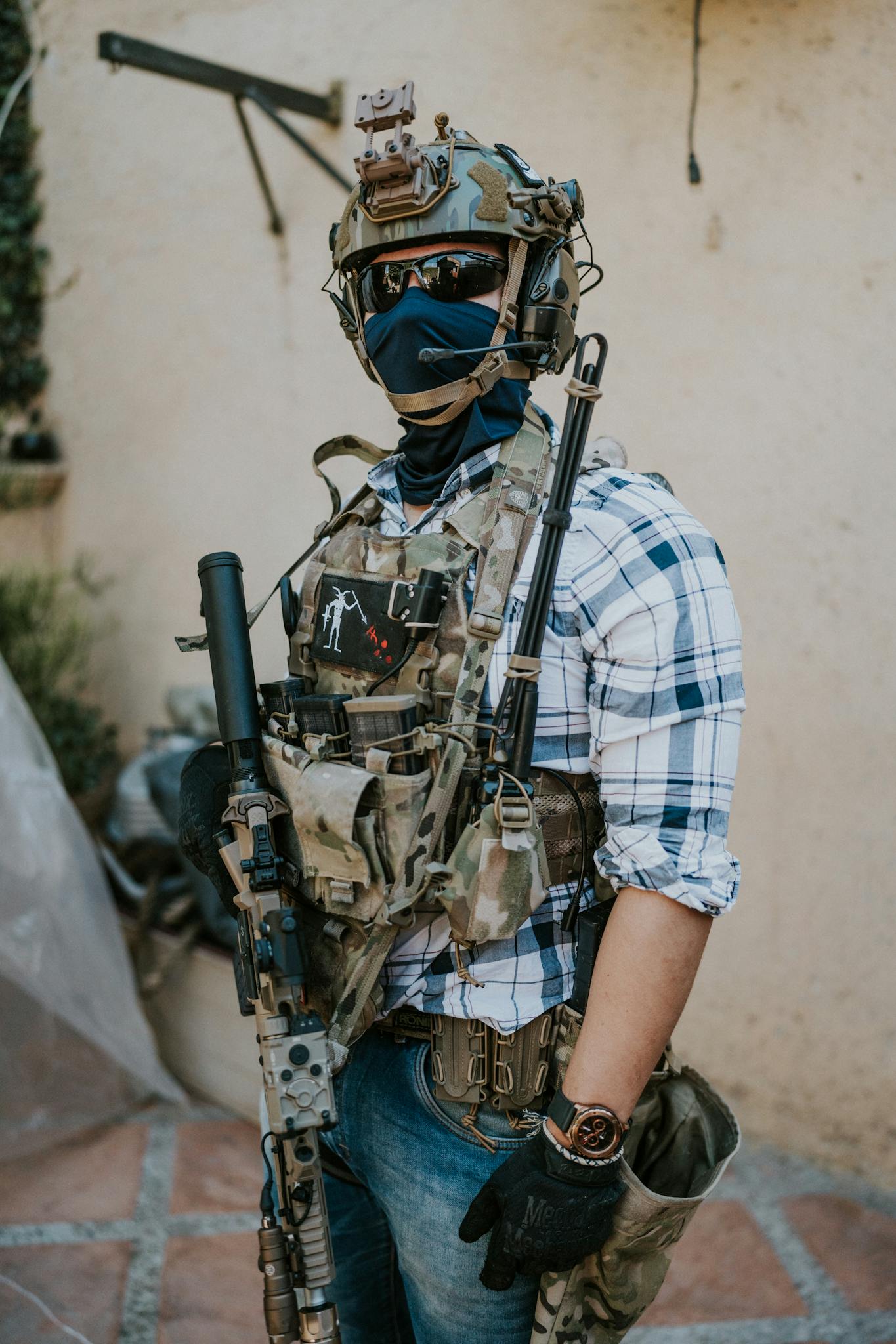 A soldier geared up with tactical equipment positioned outdoors. Ideal for military and security themes.