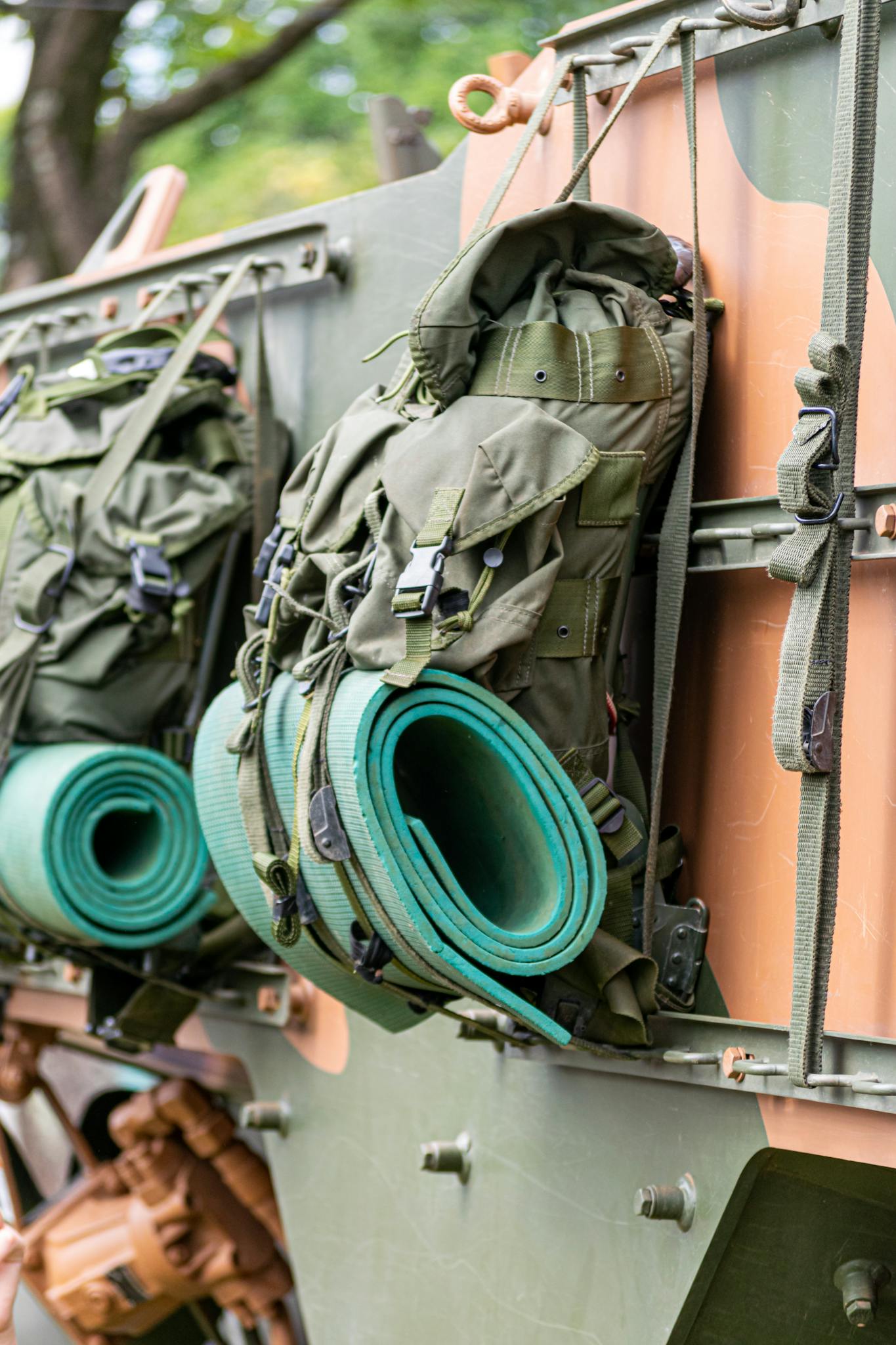 Close-up of military backpacks and equipment on a truck, showcasing outdoor gear readiness.